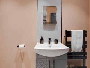 a bathroom with a white sink and a mirror at Pass the Keys Stylish Aigburth Flat Sleeps 12 in Liverpool