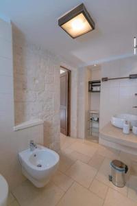 y un baño grande con lavabo y bañera. en Lunalì, en Alberobello