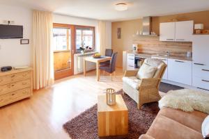 a living room with a couch and a kitchen at Haus Schmölz Ferienwohnung Allgäu in Hopferau