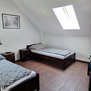 a attic room with two beds and a window at Eko Dom Eturia in Suchoraba