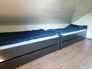 a bed with blue sheets on it in a room at Počitniška hišica Patrik Terme Čatež in Mostec +18 photos