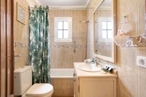 a bathroom with a toilet and a sink and a tub at Arenas del Mar in El Médano +20 photos