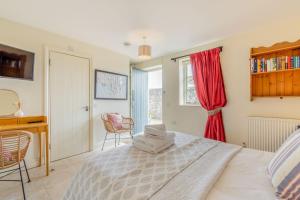 1 dormitorio con cama, escritorio y ventana en The Garden Room en Eastbourne