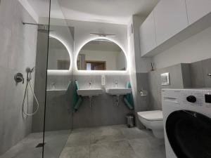 a bathroom with two sinks and a glass shower at Apartament U Wujka Żukowo in Żukowo