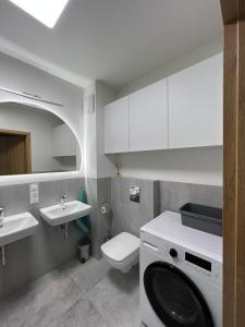 a bathroom with a washing machine and a sink at Apartament U Wujka Żukowo in Żukowo