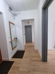 - un couloir avec des murs blancs et du parquet dans l'établissement Ultra-Central 1 Bed Apartment, str Nicolae Iorga, à Baia Mare