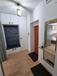 Pokój z białymi szafkami i lustrem w obiekcie Ultra-Central 1 Bed Apartment, str Nicolae Iorga w mieście Baia Mare