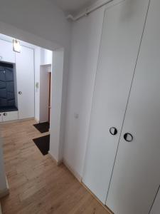 Pokój z białymi ścianami i drewnianymi podłogami w obiekcie Ultra-Central 1 Bed Apartment, str Nicolae Iorga w mieście Baia Mare