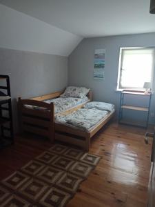 - 2 lits dans une petite chambre avec fenêtre dans l'établissement Domek w Grabówce, 