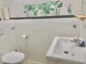 uma casa de banho branca com um lavatório e um WC em Top location single by Bahnhof Meidling em Viena
