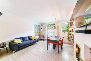 a living room with a blue couch and a table at Designer Flat in Bethnal Green in London