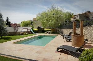 
a patio area with a pool and a bench at Can Llobet in Capmany
