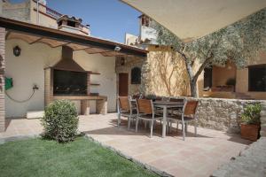 a patio with a table and chairs and a fireplace at Can Llobet in Capmany