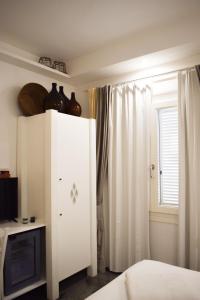 um armário branco num quarto com uma janela em Lughia em Tortolì