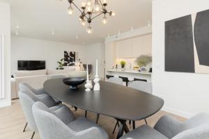 a dining room and living room with a table and chairs at LUX Apartments Domaniewska with Sauna & Gym by Renters Prestige in Warsaw