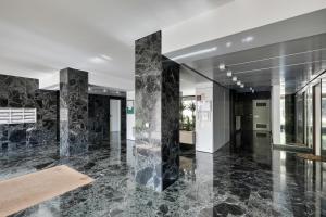 een lobby met zwarte marmeren zuilen in een gebouw bij Le Nid- Garches in Garches