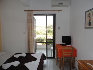 a bedroom with a bed and a desk with a computer at Archontika Apartments in Kerames
