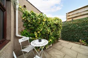 a patio with two chairs and a table next to a hedge at Heatherwood Cottage in New Scone +21 photos