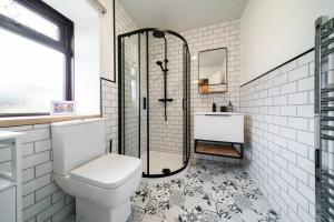 a bathroom with a shower and a toilet and a sink at Heatherwood Cottage in New Scone