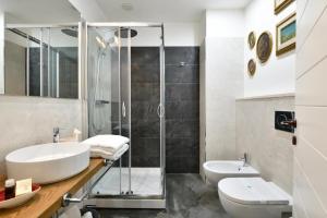 een badkamer met een wastafel, een douche en een toilet bij Lughia in Tortolì