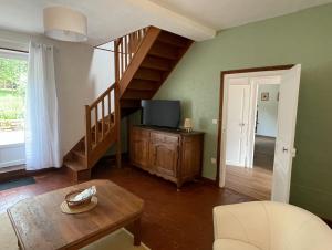uma sala de estar com uma escada e uma televisão em Gîte les érables em Forléans