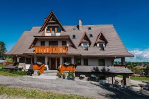 une grande maison avec un toit en gambrel dans l'établissement Dom Wypoczynkowy Orełki, à Bukowina Tatrzańska