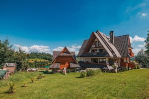 ein Haus mit einem Gamer-Dach auf einem grünen Rasen in der Unterkunft Dom Wypoczynkowy Orełki in Bukowina Tatrzańska