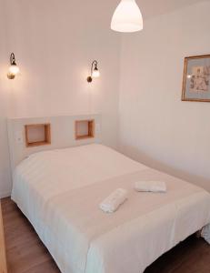 een slaapkamer met een wit bed en 2 handdoeken bij Appartement de charme à Digoin in Digoin