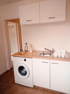 een keuken met een wasmachine en een wastafel bij Appartement de charme à Digoin in Digoin