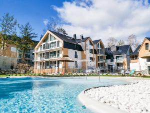 a swimming pool in front of a house at Green Apartments in Karpacz