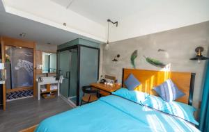 a bedroom with a blue bed and a desk at Gongxili - Chujian Hotel in Kunming