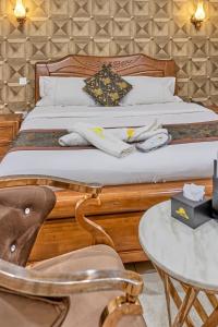 The Crest Lodge Limited في لوساكا: غرفة نوم بسرير وطاولة وكراسي