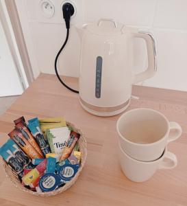 a cup of coffee next to a blender and a basket of candy at Appartement de charme à Digoin #4 in Digoin