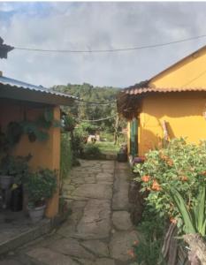 a stone path between two buildings with flowers on it at Juma Danda Lodge in Pokhara