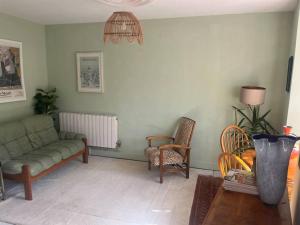 uma sala de estar com um sofá e uma cadeira em Garden Sq Bolt hole by the Sea em Kent