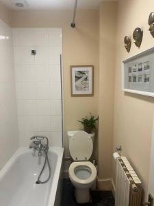 La salle de bains est pourvue de toilettes et d'une baignoire. dans l'établissement Garden Sq Bolt hole by the Sea, à Kent