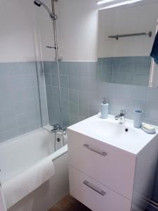 een badkamer met een witte wastafel en een bad bij Appartement de charme à Digoin in Digoin