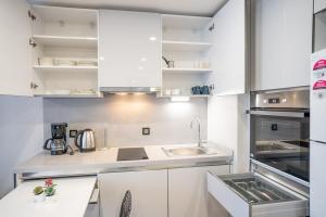 una cocina con armarios blancos y fregadero en Stylish 1-bedroom Apt- Experience City's Pulse, en Estambul