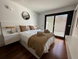 una camera da letto con un letto grande con una grande finestra di Villa Moderna Exclusiva con Jardín Privado La Villa de Sevilla a Guillena