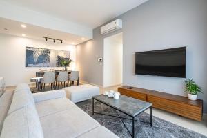uma sala de estar com um sofá e uma televisão na parede em Best View River - River Gate Apartment em Ho Chi Minh