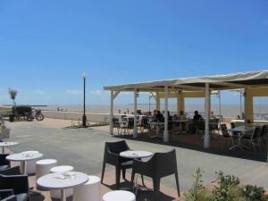 a restaurant with tables and chairs on the beach at Maison de plage in Châtelaillon-Plage