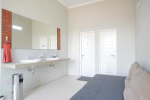 a white bathroom with a bed and a sink at Urbanview Stay at H jakal by RedDoorz in Yogyakarta +52 photos