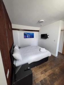 a bedroom with a white bed with a blue painting on the wall at Avenue Apartments in Hull