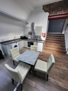 a kitchen with a table and chairs in a room at Avenue Apartments in Hull