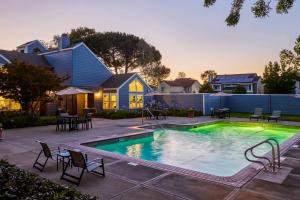 a swimming pool with chairs and tables in front of a house at Foster City 2br w gym pool wd nr shops SFO-1293 in Belmont