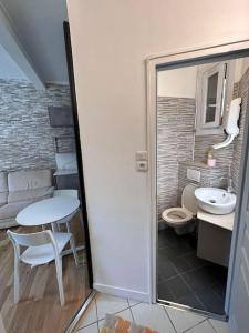uma casa de banho com um WC, uma mesa e um lavatório. em appartement moderne quai de seine em Neuilly-sur-Seine
