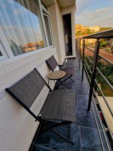einen Balkon mit 2 Stühlen und einem Tisch in der Unterkunft Apartment ''Simon Green'' in Baltschik