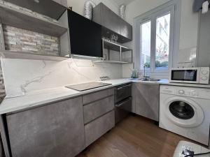 uma cozinha com uma máquina de lavar roupa e uma máquina de lavar roupa em appartement moderne quai de seine em Neuilly-sur-Seine