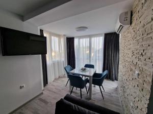 ein Wohnzimmer mit einem Tisch und Stühlen sowie einem TV in der Unterkunft Apartment ''Simon Green'' in Baltschik
