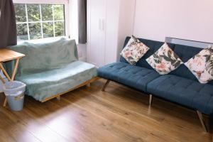 sala de estar con sofá azul y silla en Nice 4 Bedroom Apartment near City Centre 2-min Walk to Metro !! Business & Family Friendly!!, en Londres